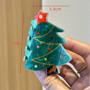 Detail view of 7cm green acetate Christmas tree hair claw clip with colorful star decor