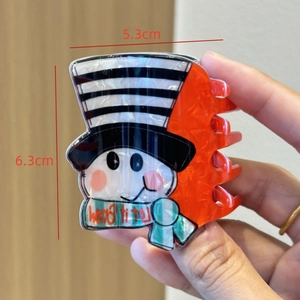 Detail view of winter snowman hair claw clip with Let It Snow scarf 6.3cm x 5.3cm size