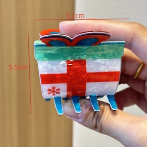 Detailed close-up of a 5.2cm Christmas gift box hair claw clip with bow and snowflake pattern