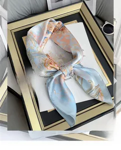 Detail of silk-like square scarf with floral print and orange border on magazine