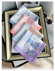 Detail of floral silk-like square scarves in pastel colors with elegant chain patterns