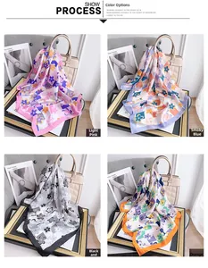 Dettaglio di quattro foulard in seta floreale nei colori rosa, blu, grigio e arancione