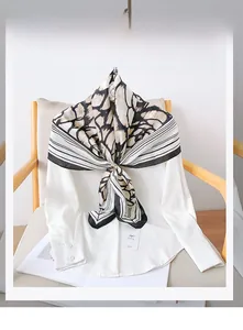Detail of black and white camellia pattern polyester scarf tied on a white shirt collar