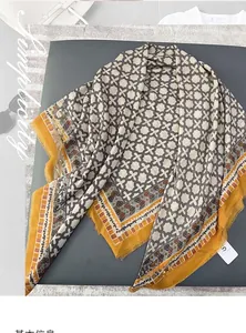Detailed view of square cotton linen scarf with gray cross pattern and yellow borders