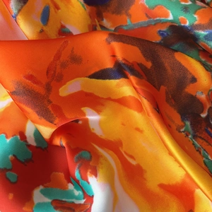 Detailed macro view of vibrant abstract watercolor pattern on silky satin beach shawl scarf
