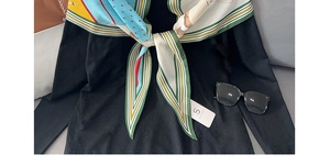 Close-up of vibrant geometric patterned silk scarf with green and blue color blocking