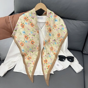 Detail of floral silk scarf on white shirt with flower patterns and branded tag
