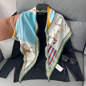Detail of equestrian print silk scarf featuring horses and geometric patterns on a sweater