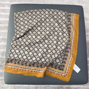 Detail of soft cotton-linen scarf with geometric pattern and ginger yellow floral border