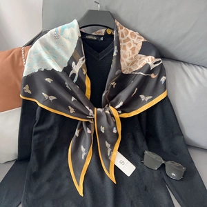 Foulard en soie avec imprimés animaux dorés et motifs de papillons sur tissu noir