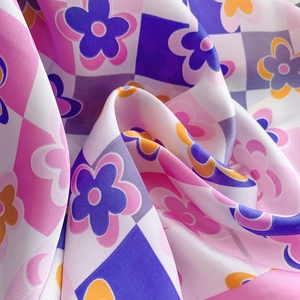 Vista macro di un foulard in seta con motivo a scacchi floreali e consistenza liscia
