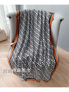 Detail of cotton linen scarf with black and white geometric pattern and orange borders