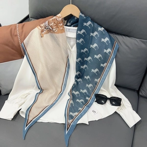 Détail d'un foulard en soie aux motifs de cheval et zèbre sur une chemise blanche