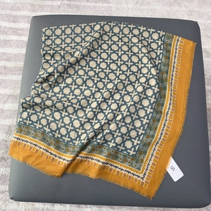 Geometric print cotton-linen scarf with yellow borders and fringe edges displayed flat