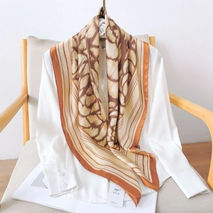 Elegant camellia silk square scarf with brown abstract prints draped on white shirt