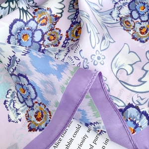 Detailed view of the purple floral silk scarf featuring neat stitched hem and smooth texture