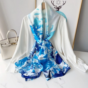 Close-up of lightweight blue and white ink print silk scarf styled with a white shirt