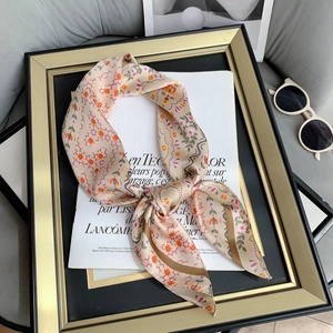 Close-up of a floral silk scarf with orange and purple patterns on a magazine background