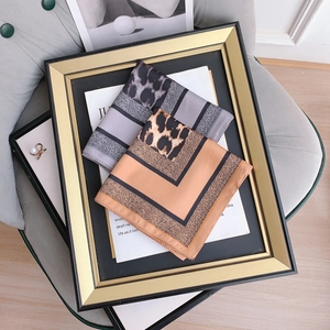 Chic leopard print and geometric silk scarves in grey and orange shown in gold frame