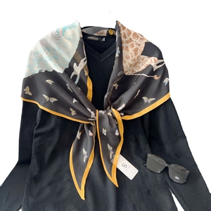 Foulard en soie à imprimé animal et bord orange sur un tricot noir avec col en V