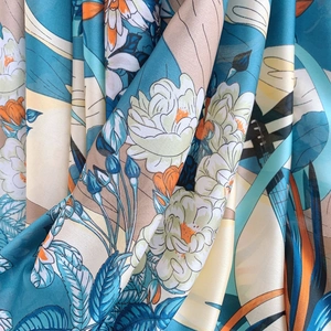 Fashion floral print silk scarf with elegant blue and orange patterns on smooth fabric