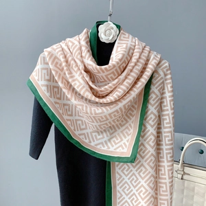 Close-up of geometric pattern jacquard scarf with contrast green border and wool texture