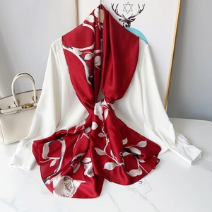 Detailed view of red rose print silk scarf tied on a shirt with elegant floral patterns