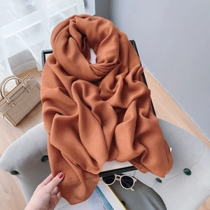 Detailed macro shot of caramel cotton linen scarf with soft pleated texture and rich color