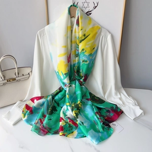 Detail of colorful abstract print silk scarf draped over a white shirt with brand tag