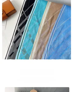 Détail d'un foulard en soie à rayures avec motifs géométriques et texture sergé