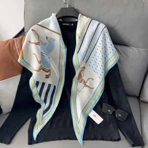 Detail of equestrian horse print scarf draped over a black V-neck knitted sweater