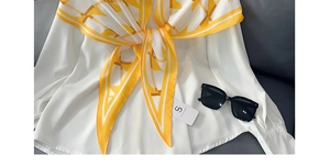 Vue détaillée d'un foulard en soie géométrique jaune et blanc avec lunettes de soleil