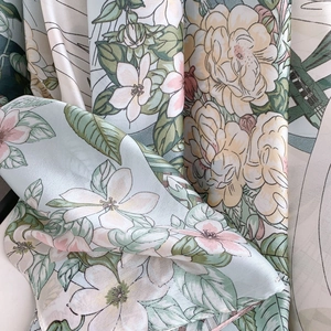 Detail of floral printed silk scarf showing soft fabric texture and mint green pattern