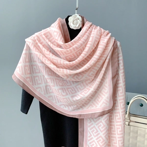 Close-up of pink and beige jacquard scarf featuring a detailed geometric G pattern