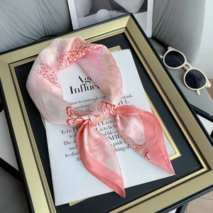 Detailed close-up of floral satin scarf with retro patterns on a vintage magazine page