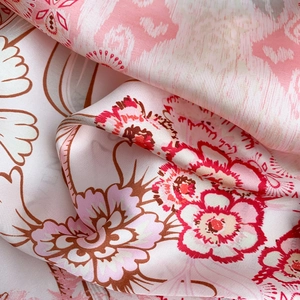 Detail of premium floral silk satin fabric with elegant drape and glossy finish