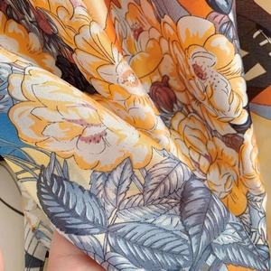 Detailed view of the soft floral print fabric with yellow roses and silky texture