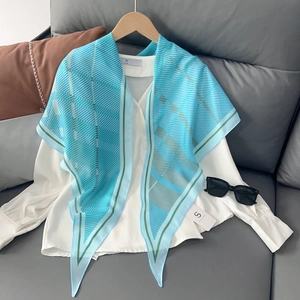 Écharpe en soie à carreaux bleus avec une chemise blanche sur un cintre en bois