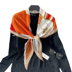 Orange diamond silk scarf with equestrian horse print styled on a black V-neck top