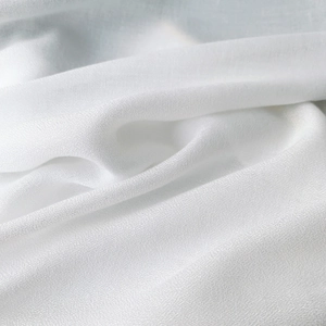 Macro detail of breathable white cotton linen fabric with natural woven texture and soft drape