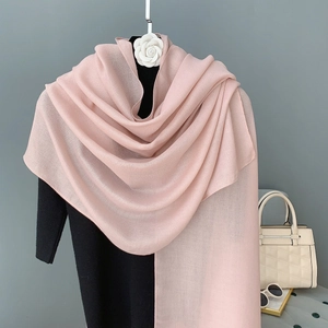 Detail view of light pink thin fabric scarf on mannequin with white camellia flower