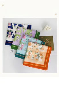 Détail de foulards en soie à fleurs en bleu marine, lilas et orange avec imprimés délicats