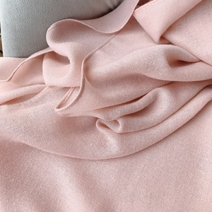 Close-up of the fine plain weave texture on a lightweight light pink cotton linen scarf