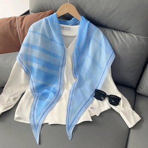 Foulard en soie à rayures bleues sur chemise blanche avec cintre en bois
