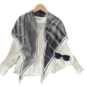 Foulard en soie rayé d'été avec motif géométrique noir et blanc sur chemise blanche