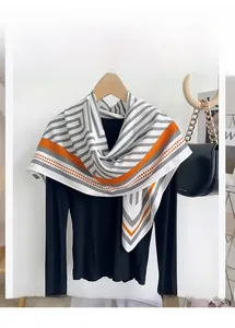 Détail montrant les rayures grises et le motif orange sur l'écharpe en polyester