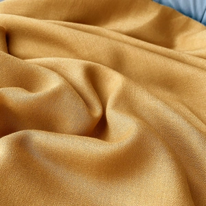 Detailed macro view of the soft golden linen cotton scarf showing delicate fabric texture