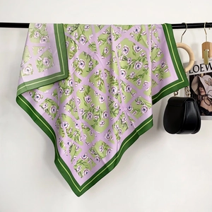 Foulard soyeux à imprimé floral et motifs géométriques sur un support élégant