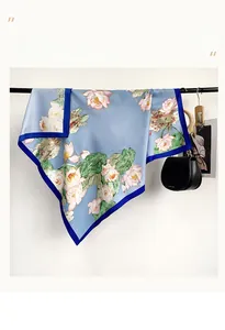 Detail of light blue silk scarf with pink lotus print and dark blue contrasting border