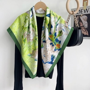 Detail of oil painting style printed silk scarf draped over a black long sleeve shirt
